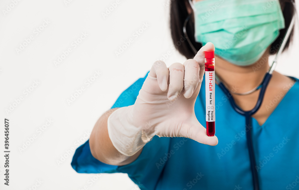 Nurse in blue uniform wear a mask holding test tube sample Coronavirus test blood in the laboratory for analyzing isolated on white background, medicine COVID-19 pandemic outbreak concept Nurse in blue uniform wear a mask holding test tube sample Coronavirus test blood in the laboratory for analyzing isolated on white background, medicine COVID-19 pandemic outbreak concept