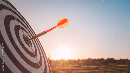 business marketing as concept. Black dart arrow hitting in the target center of dartboard Target hit in the center, goal action planing concept.