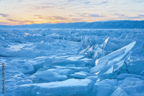 Frozen Lake Baikal. Fields of ice hummocks in the Small Sea Strait at sunset on a cold evening. Winter landscape. Natural background