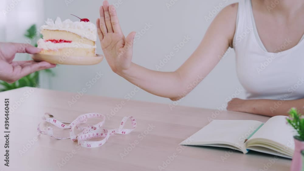 Health care women refuse to eat vanilla cake. Cake contains fat and other ingredients that affect women's health care and weight loss. Diet and control food concept. Health care women refuse to eat vanilla cake. Cake contains fat and other ingredients that affect women's health care and weight loss. Diet and control food concept.