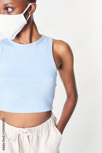Black woman in mask and blue crop tank top