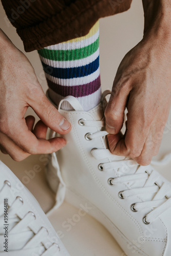 Model tying shoelaces white sneaker