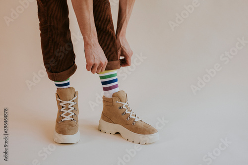 Model folding up pant leg with hiking boot