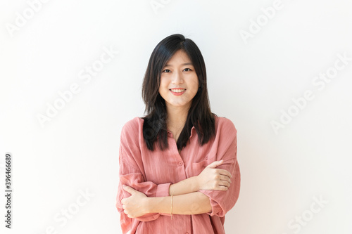 Cheerful woman standing by a white wall photo