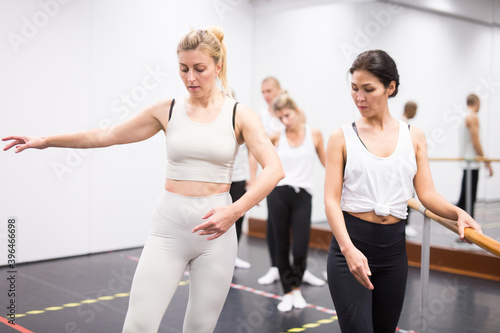 Female ballet instructor adjusting students form