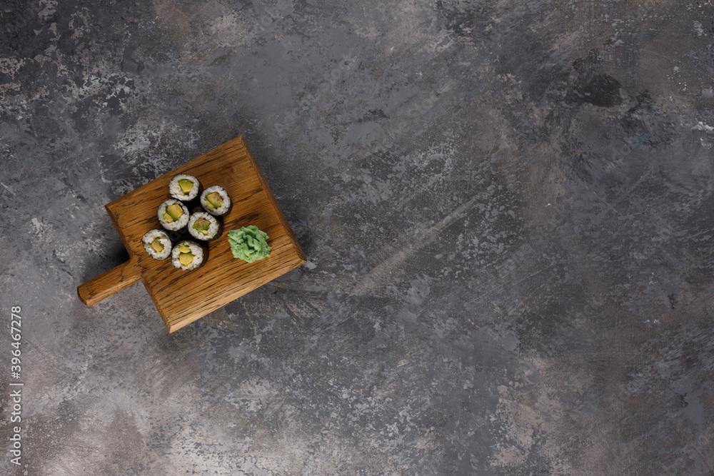 Obraz premium Appetizing rolls on a textured background. Japanese food concept. Close-up. Copy space. Flat lay.