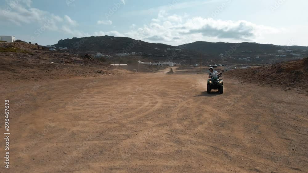 Slow motion shot of a man drifting with a quadricycle on a dirt road Slow motion shot of a man drifting with a quadricycle on a dirt road