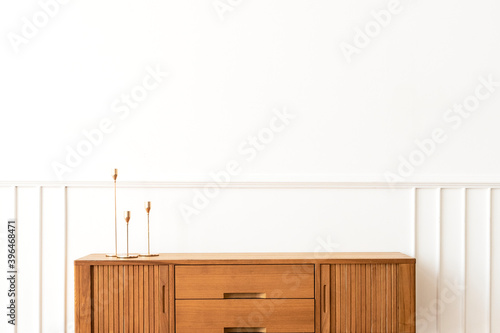 Taper candle holders on a wooden sideboard table photo
