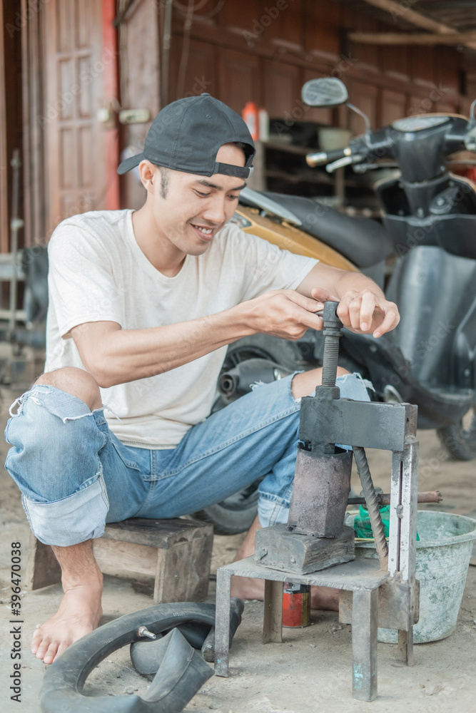 tire patcher holds the press before patching the leaky inner tube in a motorcycle repair shop tire patcher holds the press before patching the leaky inner tube in a motorcycle repair shop