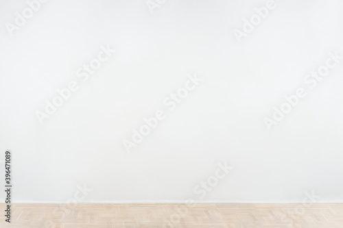 White blank concrete wall mockup with a wooden floor