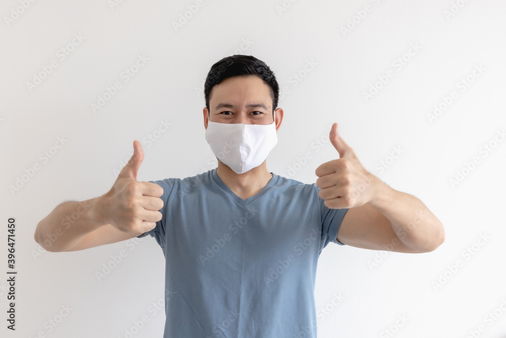 Happy and pleased expression of Asian man in white mask on isolated background. Happy and pleased expression of Asian man in white mask on isolated background.