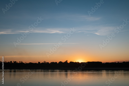 Sunset sky with graduated colors over Mekong riverbank, blue and orange colored sky background. © Nkt.Nipharat