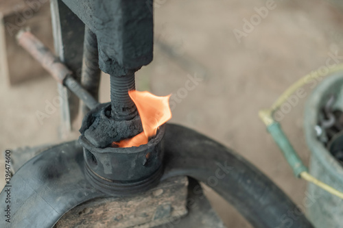 top view of flame on a traditional press tool when patching a motorbike tire in a tire repair shop