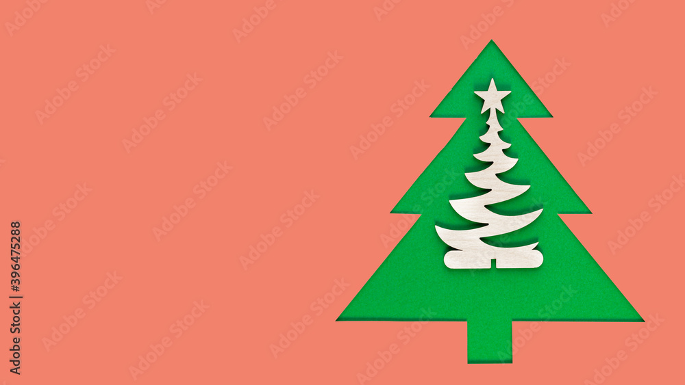 Christmas tree cut out of paper on a pink background. Silhouette of Green christmas tree. Christmas tree paper cutting design card. Paper Art with copy space. Long wide banner Christmas tree cut out of paper on a pink background. Silhouette of Green christmas tree. Christmas tree paper cutting design card. Paper Art with copy space. Long wide banner