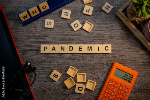 Alphabets spelled PANDEMIC flat lays on wooden background layouts.