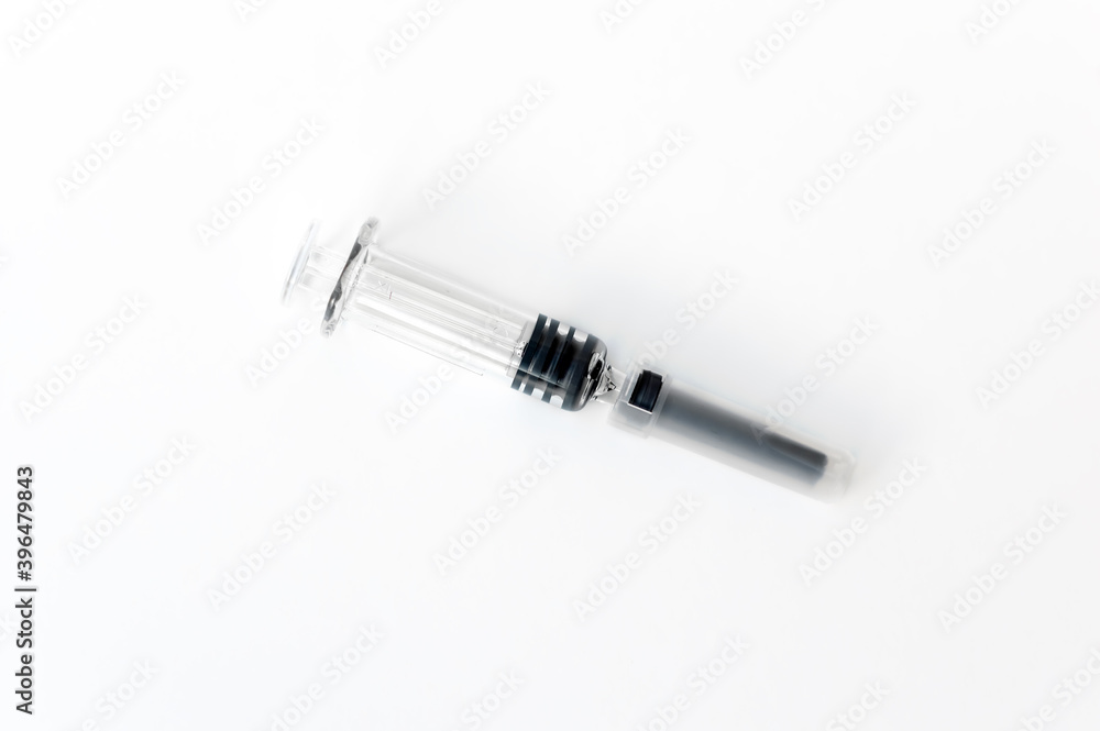A syringe with a needle and a cap for medical vaccination on a light background lies on the table. copy space. flatlay. A syringe with a needle and a cap for medical vaccination on a light background lies on the table. copy space. flatlay.