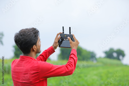 Remote control holding in hand over agriculture background