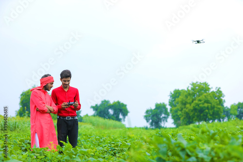 Indian farmer and agronomist using drone at agriculture field © PRASANNAPIX