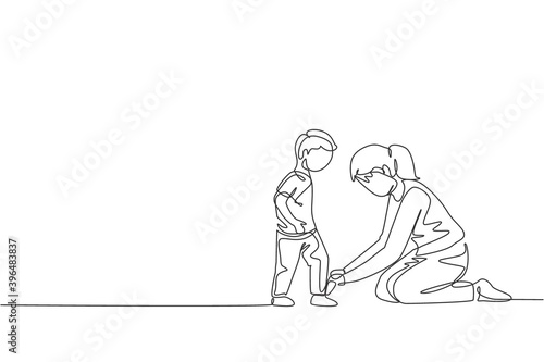 One continuous line drawing young happy mom at home tying her son shoelaces before going to school in the morning. Family parenting concept. Dynamic single line draw design vector illustration graphic