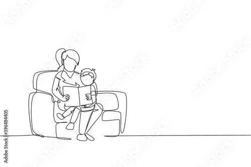 One single line drawing young happy mother and her son siting on sofa reading a story book together vector graphic illustration. Family parenting education concept. Modern continuous line draw design