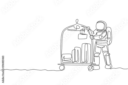 One single line drawing of young room boy astronaut pushing luggage trolley with suitcases and bags vector illustration. Hotel service. Cosmonaut deep space concept. Modern continuous line draw design