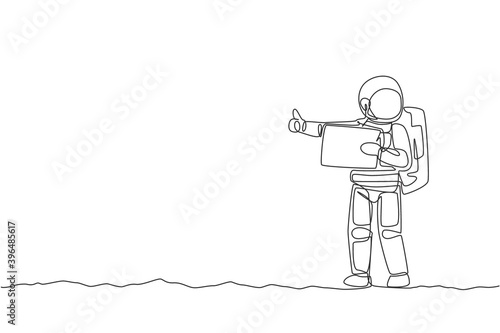 One single line drawing of astronaut hitchhiker holding paper board and wait at side of the road in moon surface vector illustration. Cosmonaut deep space concept. Modern continuous line draw design