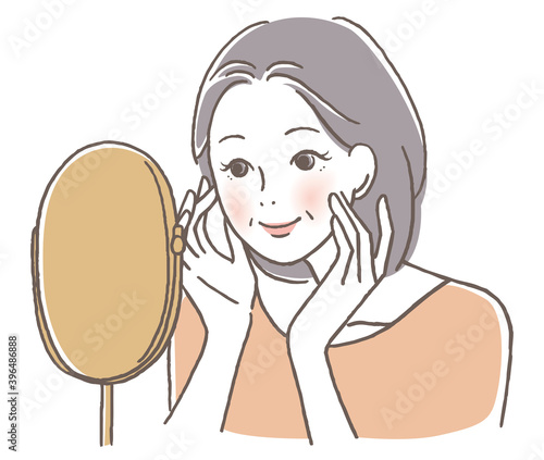 鏡を見て微笑むシニア女性