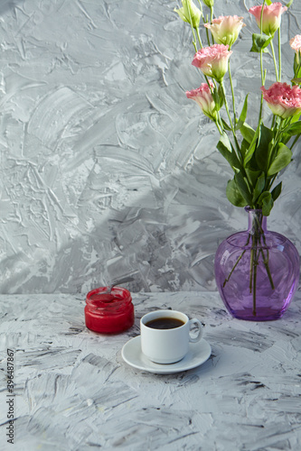 Wonderful breakfast. A bouquet of pink eustoma flowers on a gray background. A Cup of black coffee is nearby © Мария Чичина