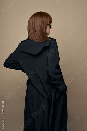 Attractive woman dark coat attractive appearance rejoicing on an isolated background 
