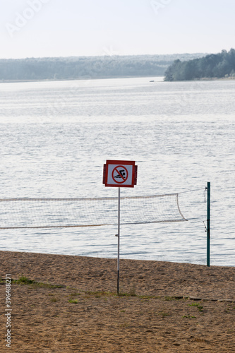 beach with a volleyball court and a swimming sign is not allowed