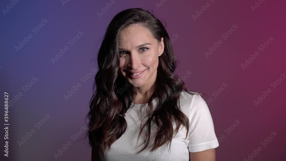 nice brunette girl in a white t-shirt with long hair opens the door to the holiday and she is happy and surprised close-up portrait. High quality FullHD footage Slow motion nice brunette girl in a white t-shirt with long hair opens the door to the holiday and she is happy and surprised close-up portrait. High quality FullHD footage Slow motion