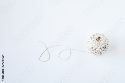 Top view roll of cotton natrue string twine on white background and space for text. Crafting supply, decoration book, or tie a present box.