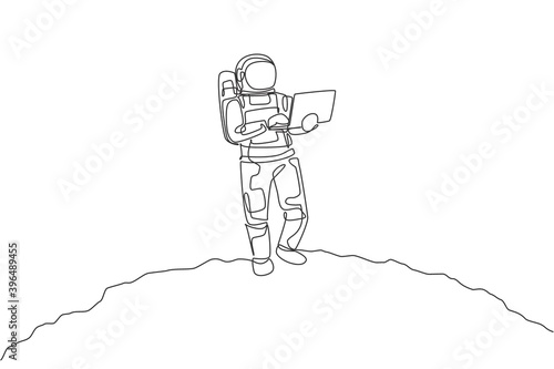 Single continuous line drawing of astronaut standing in moon surface while typing using laptop. Business office with galaxy outer space concept. Trendy one line draw design graphic vector illustration