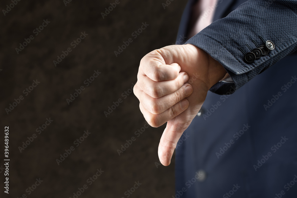 Fototapeta premium businessman thumbs down gesture. Businessman hand showing thumb down sign gesture. Dislike or bad concept