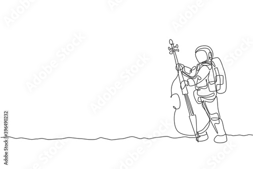 One single line drawing of spaceman cellist playing cello musical instrument on moon surface vector illustration. Music concert poster with space astronaut concept. Modern continuous line draw design