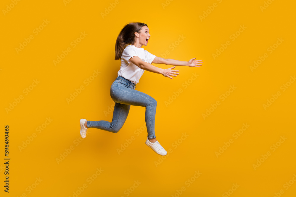 Full length body size side profile photo of young girl jumping high embracing copyspace isolated on vivid yellow color background