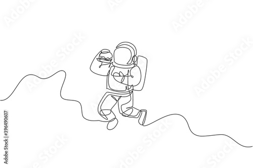 One continuous line drawing of cosmonaut eating fresh delicious burger in galactic universe. Fantasy outer space astronaut life concept. Dynamic single line draw design vector illustration graphic