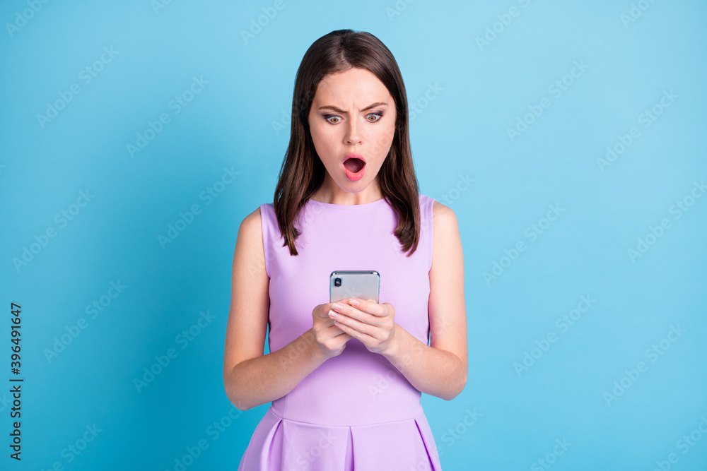 Photo of shocked brown haired woman wear violet singlet hold look phone isolated on blue color background