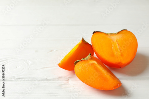 Fresh ripe persimmon on wooden background, space for text