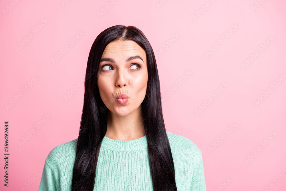 Photo portrait of dreamy female student looking at blank space with pouted lips isolated on pastel pink color background Photo portrait of dreamy female student looking at blank space with pouted lips isolated on pastel pink color background