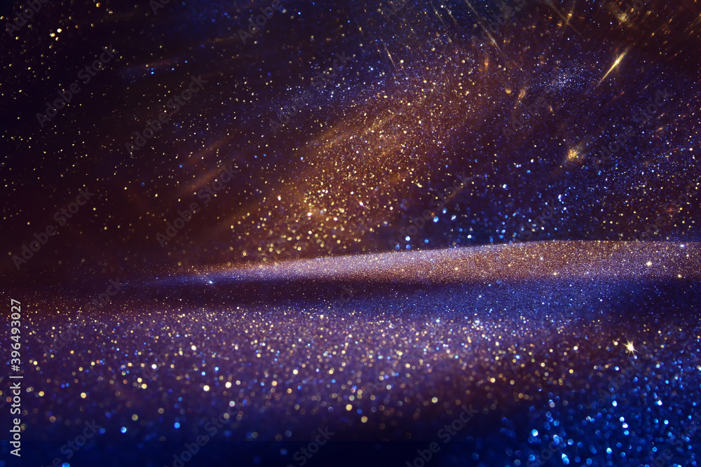 Obraz premium background of abstract glitter lights. Gold ,blue and black. de focused