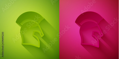 Paper cut Greek helmet icon isolated on green and pink background. Antiques helmet for head protection soldiers with a crest of feathers or horsehair. Paper art style. Vector.