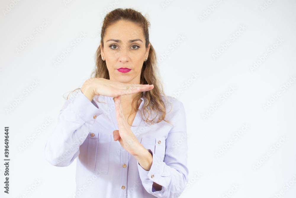 Young beautiful woman wearing casual shirt over white background Rejection expression crossing hands doing negative sign, angry face Young beautiful woman wearing casual shirt over white background Rejection expression crossing hands doing negative sign, angry face