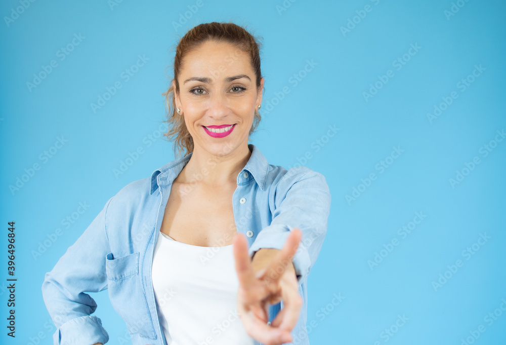 Young caucasian woman isolated showing victory sign and smiling over blue background. Young caucasian woman isolated showing victory sign and smiling over blue background.