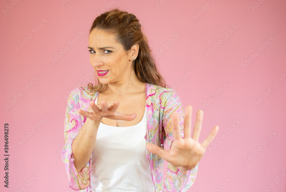 Young beautiful woman wearing casual clothes over pink isolated background Moving away hands palms showing refusal and denial with afraid and disgusting expression. Stop and forbidden. Young beautiful woman wearing casual clothes over pink isolated background Moving away hands palms showing refusal and denial with afraid and disgusting expression. Stop and forbidden.