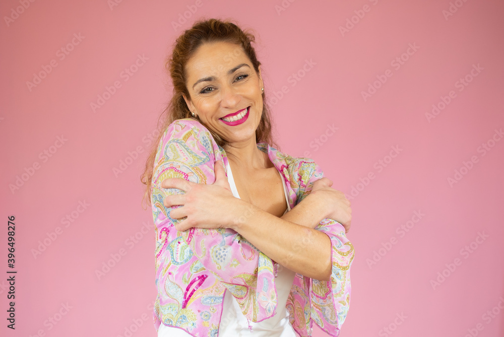 Portrait of a pretty young woman in casual shirt hugging herself. Concept of selfish emotion. Portrait of a pretty young woman in casual shirt hugging herself. Concept of selfish emotion.