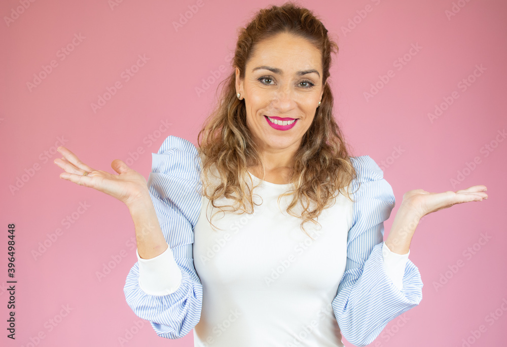 Beautiful caucasian woman pink over isolated background clueless and confused expression with arms and hands raised. Doubt concept. Beautiful caucasian woman pink over isolated background clueless and confused expression with arms and hands raised. Doubt concept.
