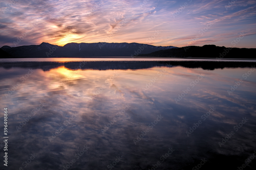 ドラマチックな空を湖面に反射する黄昏のカルデラ湖
