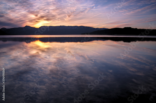 ドラマチックな空を湖面に反射する黄昏のカルデラ湖