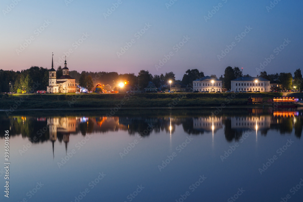 embankment of an ancient city reflected in the river in the evening
